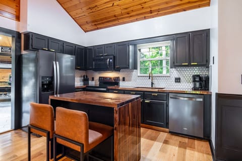 Fully equipped modern kitchen with sleek black appliances and cozy breakfast bar!