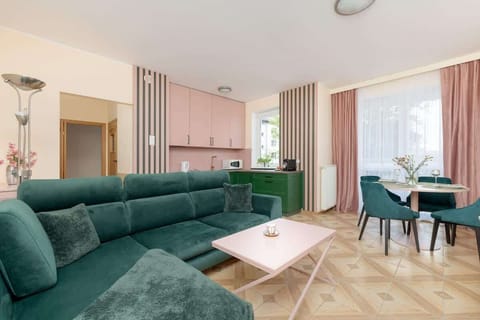 Large windows in the living room brighten the interior and highlight the modern décor, creating a fresh and airy atmosphere.