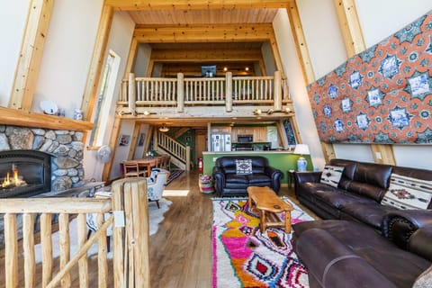 The home boasts soaring ceilings with exposed wood beams and an open layout offering an inviting space for groups to relax together.