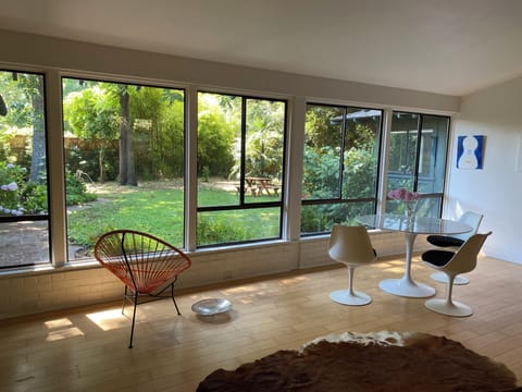 Living room view of backyard. Circular dining table to the right.