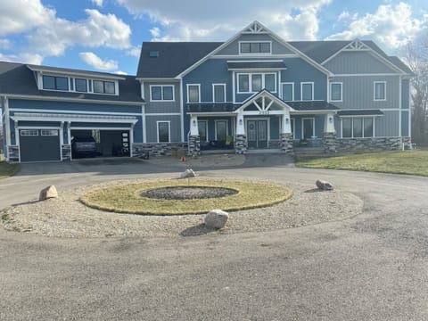 Circle driveway and front porch with sectional and chairs.
