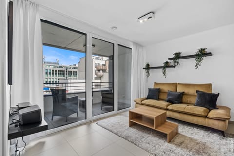 Enjoy a bright and airy living room with direct access to a private balcony, perfect for relaxing with a cup of coffee or a good book. The space is complemented by a comfortable sofa and modern decor.