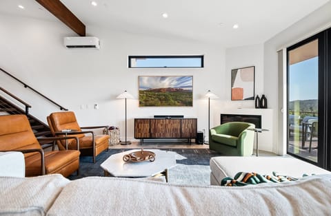 Spacious living area with comfortable furnishings, picture frame smart TV, electric fireplace, and surrounding views