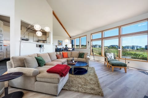 Open floor plan living space with large windows that maximize the view of the golf course and ocean.