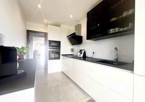 Cuisine moderne et fonctionnelle. Le rangement intégré garantit un espace dégagé, idéal pour cuisiner en famille. Imaginez l'atmosphère conviviale pour le petit déjeuner avec le café fraîchement préparé.