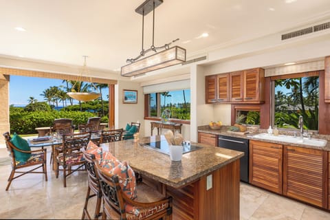 Gourmet kitchen with granite countertops, Koa cabinetry, and a central prep island.