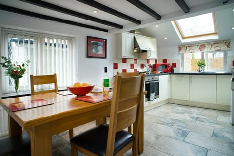 Dining area with wood table and chairs and kitchen area