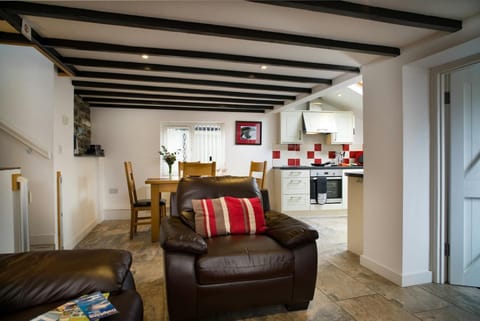 Living area with armchair, view of dining and kitchen areas