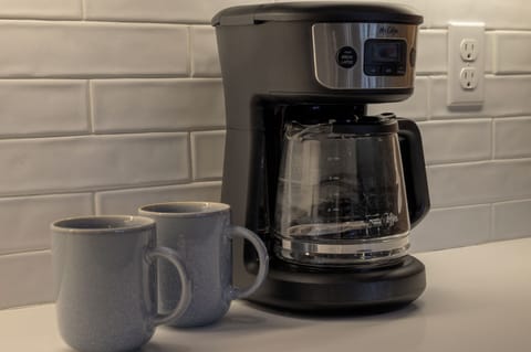 - Morning routines are easy with this sleek drip coffee maker and matching mugs - Subway tile backsplash and clean white counters add charm to the setup - Brew your favorite blend and savor it at the island or out on the mountain view deck