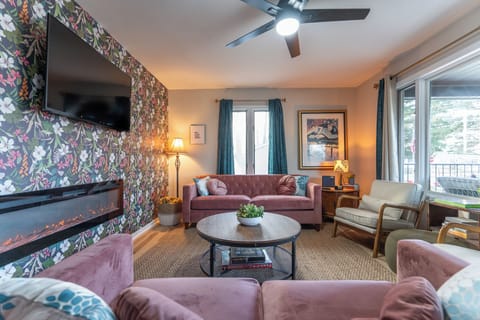 Design forward living room with plenty of seating, electric fireplace & TV