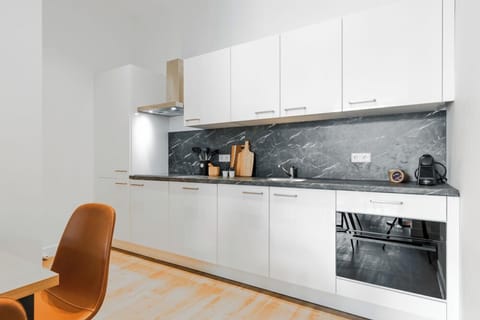 Modern kitchen with sleek white cabinetry, marble backsplash, and fully equipped for preparing delicious meals during your stay.

Studio appartement in Tilburg met gloednieuwe keuken – ideaal voor goedkoop overnachten vlakbij Tilburg Centrum, de universiteit, Efteling & Safaripark Beekse Bergen.