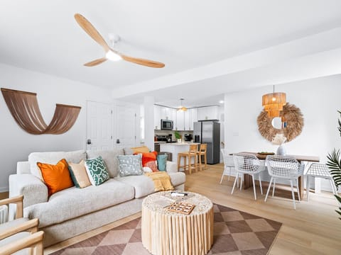 Spacious open-concept layout connecting living room and kitchen - Vibrant sofa with colorful pillows brightens up the cozy space - Perfect Airbnb setup for gatherings, dining, and relaxation