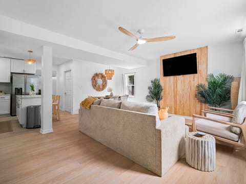 Open-concept living space with cozy seating and bright décor - Large sofa and armchairs arranged for comfort and gatherings - Airbnb layout designed for entertainment and relaxation