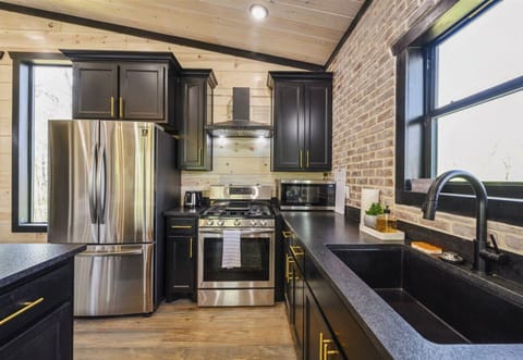 Modern meets rustic in our kitchen where state-of-the-art appliances are set against a backdrop of warm brick and wood