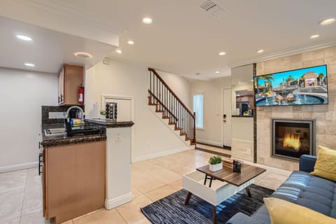 Sophisticated living room design with a sofa that opens up to full-size beds, 55” Smart TV, office/kitchen seating, beautiful decor, and much more.