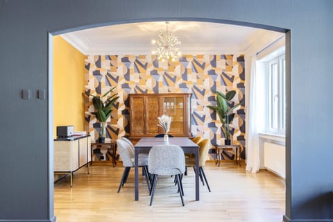 Charming dining area with vibrant wallpaper and natural light, offering a delightful space for meals and gatherings.