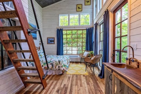 The interior features a queen bed on the main floor with extra sleeping arrangements in the loft.
