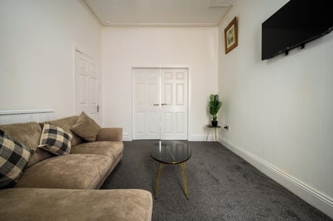 Bright and spacious living room with plenty of seating, central heating, double glazed window, sofa with table, tv etc.