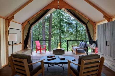 Spacious glamping tent with a comfortable seating area and breathtaking forest views.