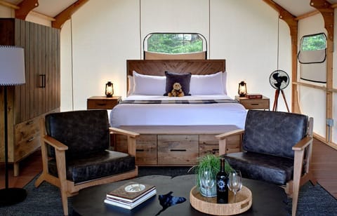Cozy and stylish glamping interior featuring a plush bed and sitting area for ultimate relaxation.