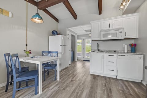 Kitchenette with 2 burner cooktop, full fridge, dishwasher, and a crockpot.
