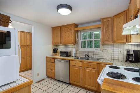 Kitchen with dishwasher, coffee grinder, and standard drip coffeemaker.
