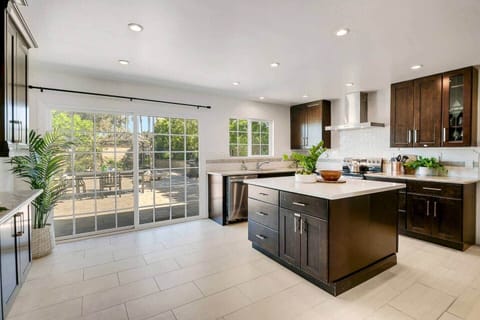 Kitchen with large island, dishwasher, sink, refrigerator, electric stove, oven