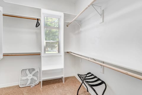 Spacious walk-in closet with ample shelving and hanging space.