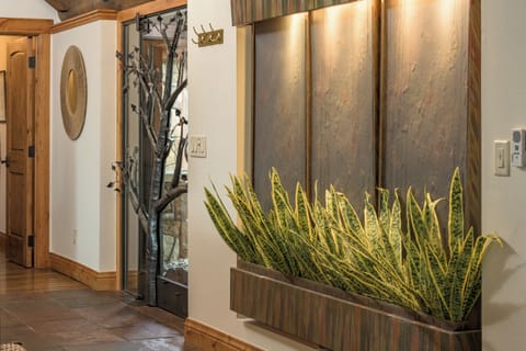 The Grand Foyer - Entryway with plant wall art, vaulted ceilings, and custom timber-work.