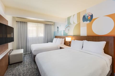 Unwind in bright twin-queen comfort with playful mural accents.