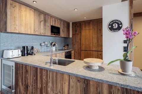 Prepare delicious meals in this fully equipped modern kitchen, featuring high-end appliances, ample counter space, and a cozy breakfast bar for casual dining.