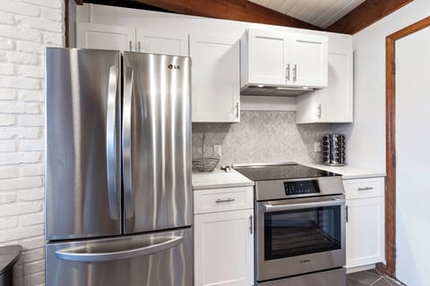 Kitchen with stainless appliances, dishwasher, Keurig and drip-style coffee pot, and access to the garage.