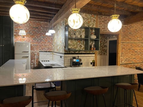 Fully equipped kitchen with marble counter and stylish lighting in an Art Deco holiday flat in Brussels.