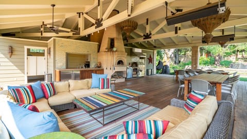 The outdoor lounging area sits under exposed beans and a stunning summer kitchen