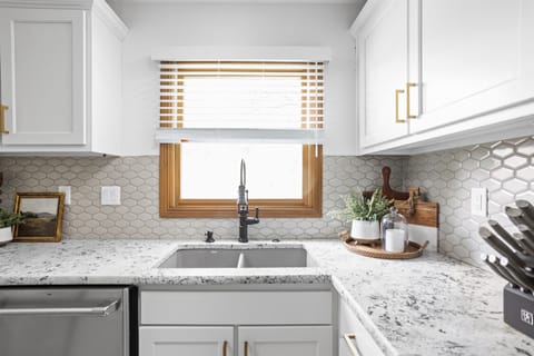 Behold our newly upgraded kitchen, showcasing sleek countertops and a stunning backsplash that elevate both style and functionality.