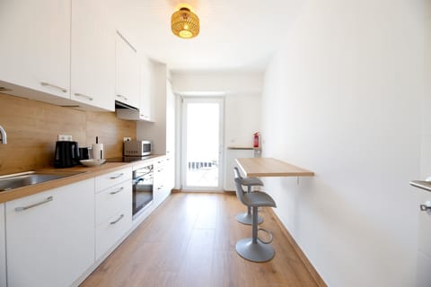 Prepare meals in our fully equipped kitchen, featuring modern appliances and a convenient breakfast bar for casual dining.