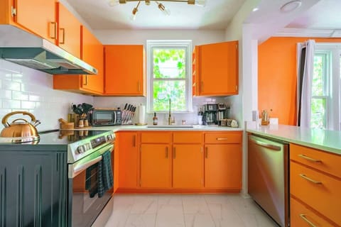 This kitchen shines with its energizing orange cabinetry, making a lively statement that’s impossible to ignore.