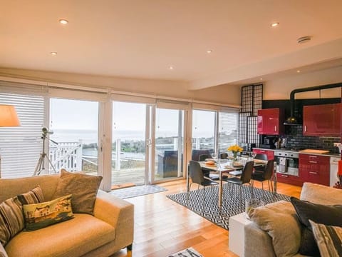 Open plan kitchen/diner with sliding doors to balcony with stunning sea views