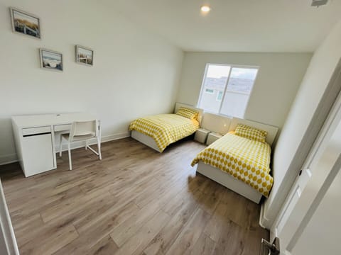 spacious guest room with 2 twin beds and working desk