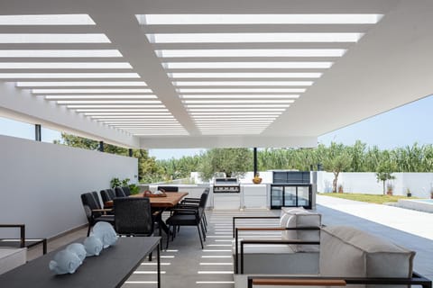 The outdoor space boasts a gas BBQ grill, complete with a mini fridge, ample counter space, and storage cabinets.