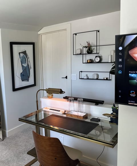 Open concept room with double bed, TV, closet, desk, TV, chargers and Alexa