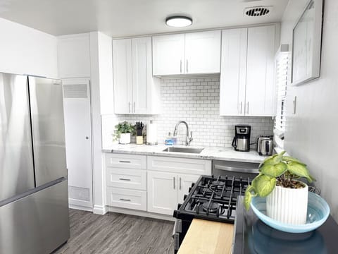 Fully stocked kitchen featuring a full-sized fridge, gas range, dishwasher, and modern finishes—perfect for cooking during your stay.