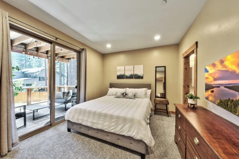 Bedroom 2 on 1st floor with queen bed, sliding glass door to balcony, and HDTV