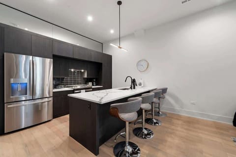Contemporary kitchen featuring white cabinetry, a central island, and stainless-steel appliances.