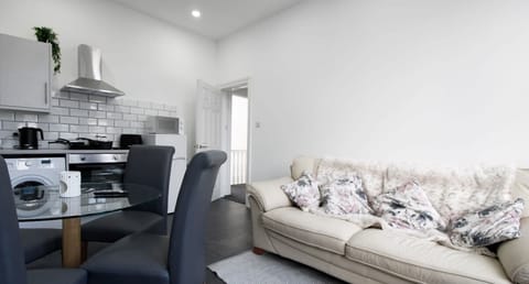 Central to the lounge find a glass round dining table with 4 grey chairs.