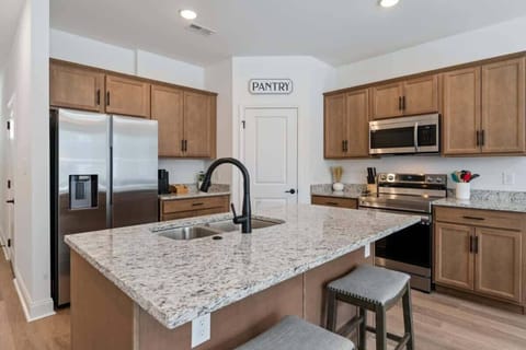 Our fully furnished kitchen features stainless steel appliances, cookware, plates, utensils, and everything you need to prepare delicious meals. There are also bar seats for two.