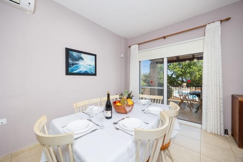 Open-plan living room with sofa, dining area, kitchen, ornamental fireplace, A/C, WiFi internet, and satellite TV