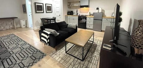 Modern and inviting open-concept living space with a fully equipped kitchenette, chic décor, and plush seating—ideal for a relaxing escape.