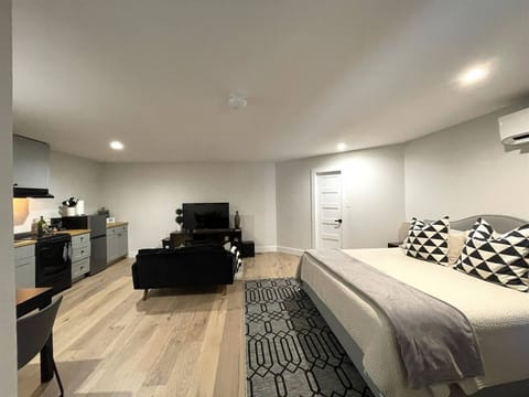 Generous studio featuring a king-sized bed, sleek kitchenette, and inviting living area—perfect for a comfortable, convenient stay.