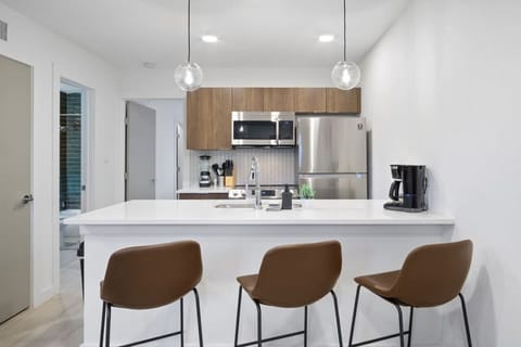 This contemporary kitchen is a chef's dream, featuring a large island, modern stainless steel appliances, and sleek cabinetry. The open layout ensures you can cook and entertain effortlessly, making it the perfect space for culinary creativity and social